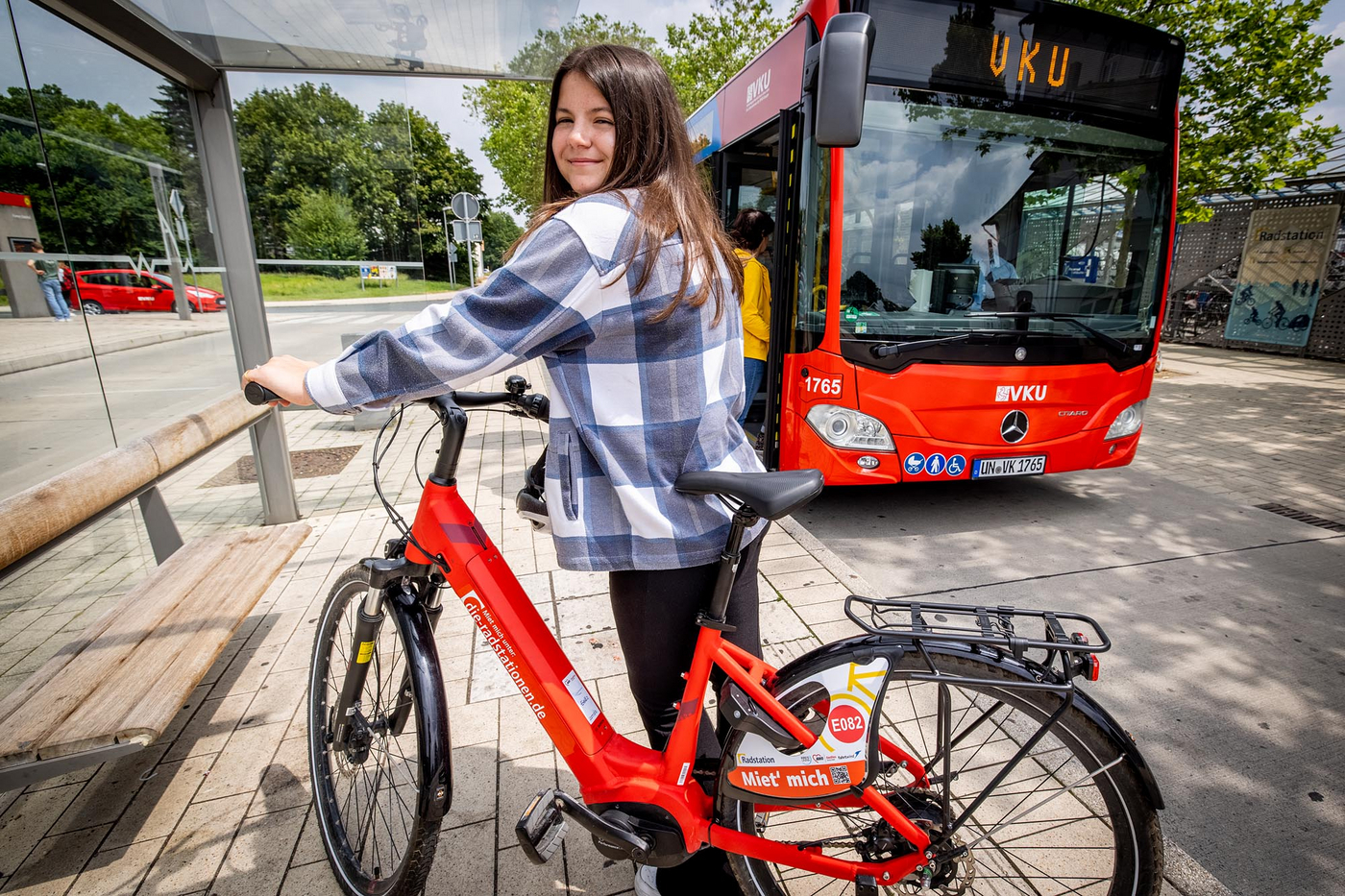 Ein Mädchen steht am Fahrrad und lächelt.